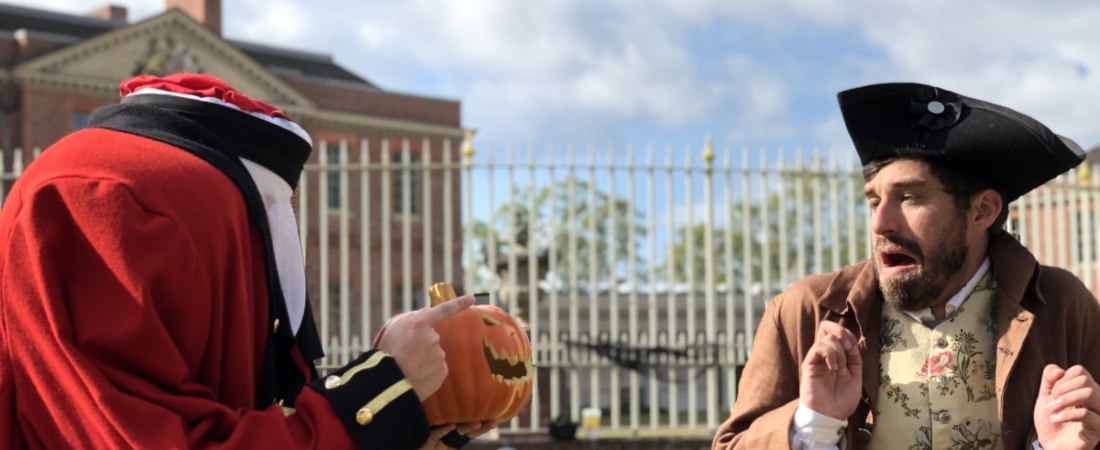 Man with missing head holding pumpkin at scared man