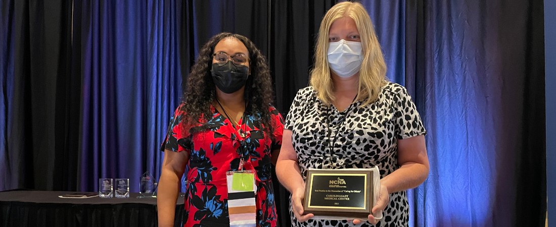 Two CarolinaEast Nurses holding award plaque