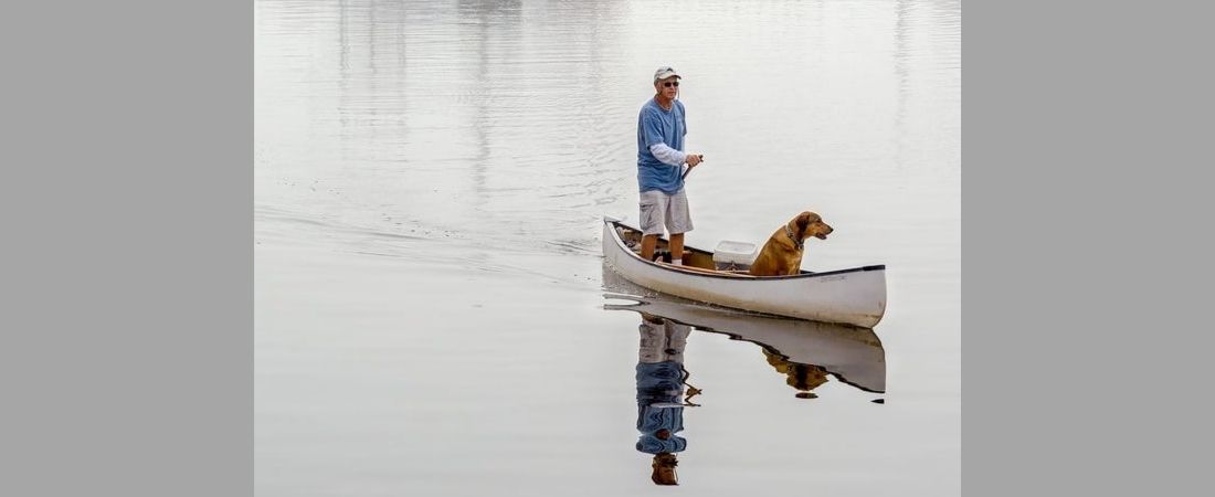 Photo of man and dog in canoe - "Canoe Buddies" by Rick Gourly