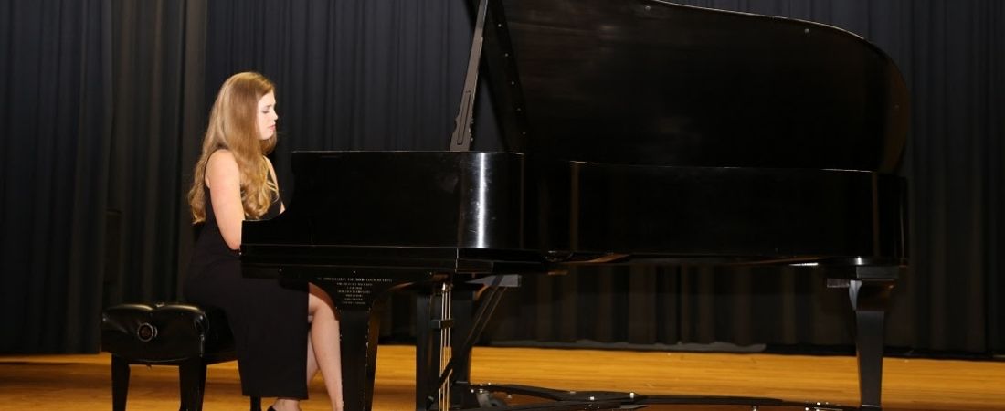 Shauna Brierly in black gown at piano