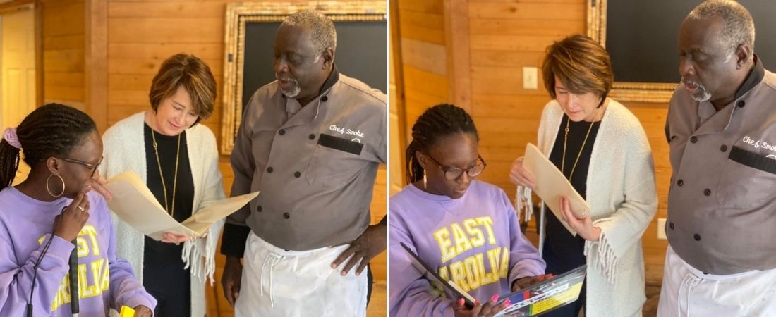 Acacia Bragg, Carol Stubbs, and Chef Smoke look at braille menu at Captain Ratty's Restaurant