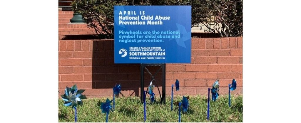 National Child Abuse Prevention Month sign and pinwheels.
