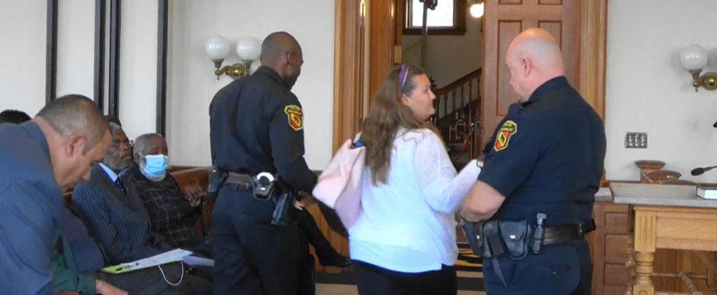 New Bern Citizen being escorted out of Board of Aldermen Meeting