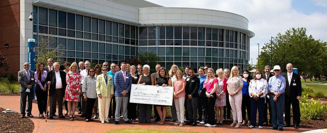 Staff holding large check