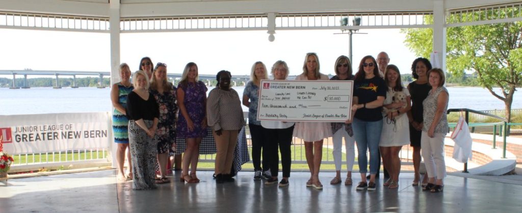 Junior League of Greater New Bern holding check at Union Point Park Gazebo