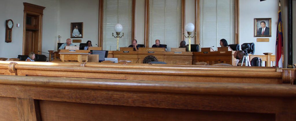 Alderman Rick Prill of Ward 1, Alderman Hazel Royal of Ward 2, Alderman Bobby Aster of Ward 3, Mayor Jeffrey Odham, Alderman Johnnie Ray Kinsey of Ward 4 and Alderman Barbara Best of Ward 5 in the courtroom at City Hall in downtown New Bern taken on Aug. 2, 2024. (Photo by Wendy Card)