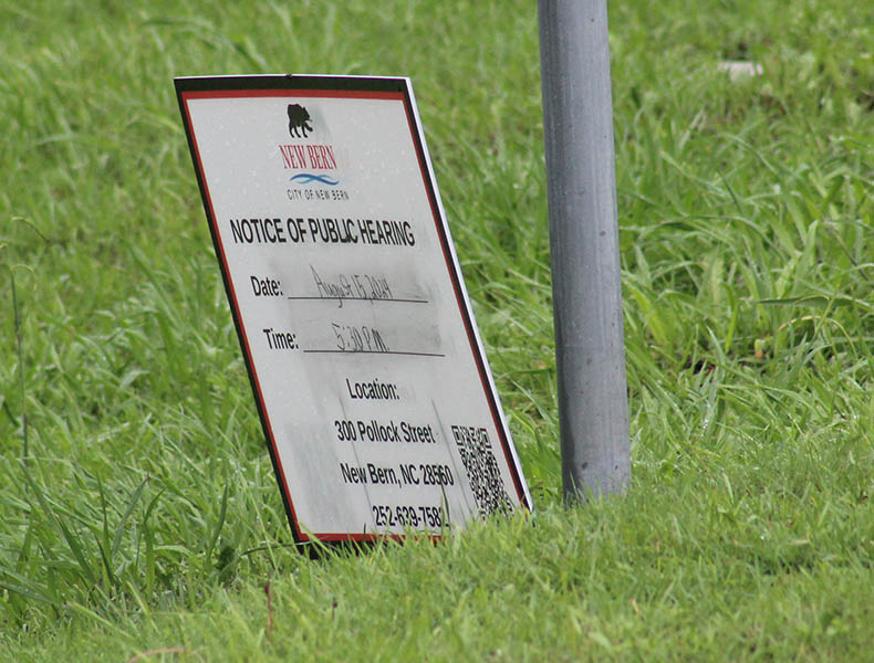 A sign for a public hearing was posted at the corner of Rainmaker Drive and Washington Post Road on Aug. 8, 2024. 