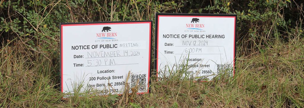 Notice of public hearing and meeting signs posted next to West Pleasant Hill Drive. (Photo by Wendy Card)