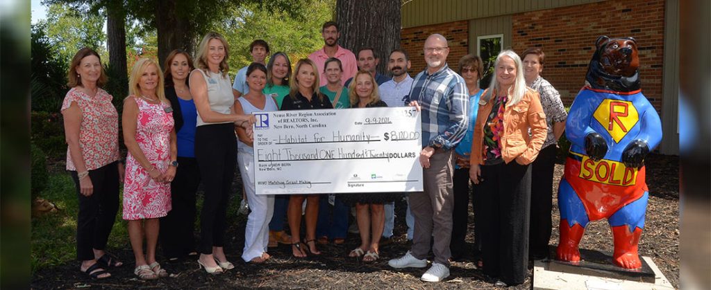 Brittany Blizzard, NRRAR president, presents HFHCC Board President Chip Payson with a check for a Matching Grant on Wednesday, September 9. Also pictured are: Marie Phillipsn; Kristi Diello; Whitney Woodall, NRRAR Association Executive; Meredith Morse; Debi Edwards, Neuse River Region Multiple Listing Service President; Billie Jo Stewart; Johnny Harrison; Lillian Horne; Annmarie Conta; Josh Reason, HBA President; Michael Raines; Austin Bayliss; Rosemarie Doshier, NC Housing Foundation; Lori Neill, HBA executive Officer; and Tracey Lilly, HFHCC Executive director.