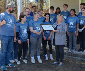 Rose MacNeal, Habitat for Humanity board president and chair, presents a certificate to students and alumni from the University of Delaware thanking the school for its help with Habitat home building projects over the last decade. Photo by Todd Wetherington.