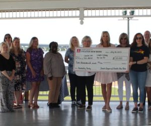 Junior League of Greater New Bern holding check at Union Point Park Gazebo