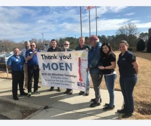 People holding thank you Moen banner