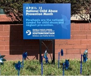 National Child Abuse Prevention Month sign and pinwheels.