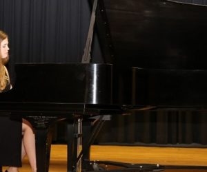 Shauna Brierly in black gown at piano