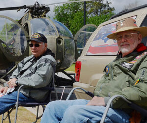 Ed Hughes, right, and Danny Elzie, Army veterans who served in the Vietnam War, sit near a Hughes OH-6 Cayuse helicopter Wednesday's Vietnam War Veterans Day recognition event at Union Point Park. Photo by Todd Wetherington.